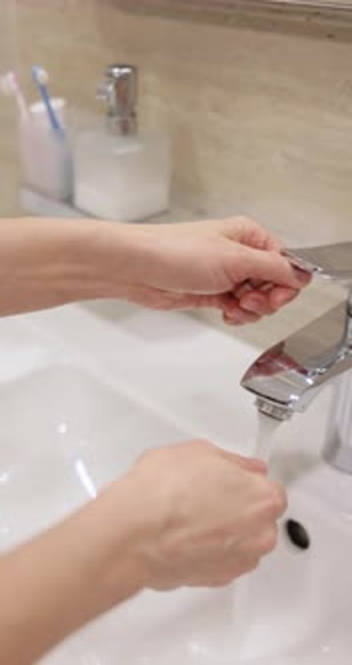 Woman Wash Her Hands in Sink in Bathroom