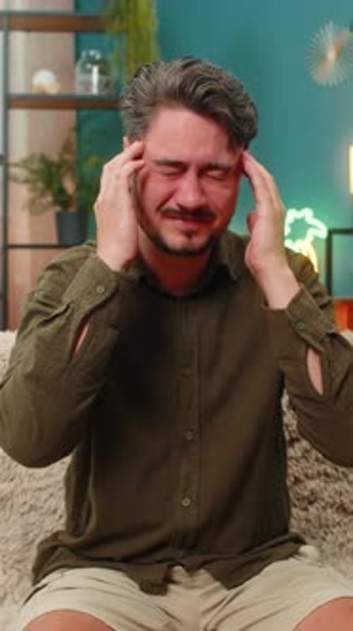 Hombre de mediana edad que se masajea la cabeza dolorida sufre dolor de cabeza, tensión, migraña, dolor que busca alivio y comodidad