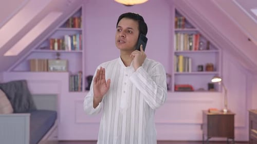 Hombre indio enojado gritando en el teléfono móvil