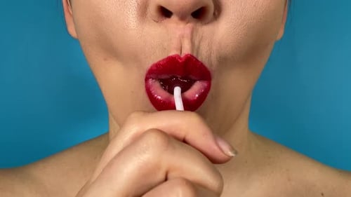 Gros plan : bouche féminine, lèvres colorées, mange des aliments sucrés, fond isolé