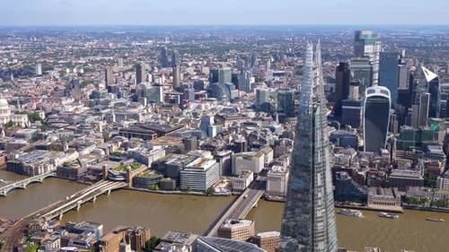 Aerial view of the Shard and London City, pan west to show the River Thames and bridges. London, UK