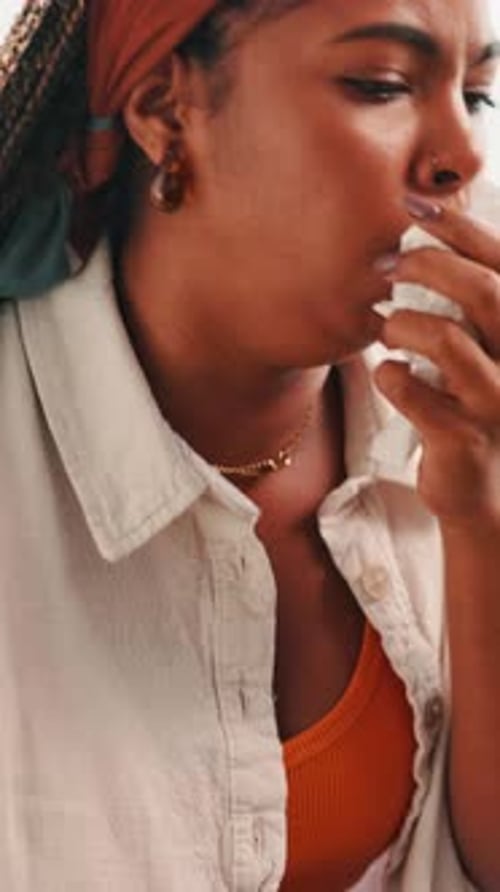 Mujer enferma que tose con pañuelos desechables en casa por infección respiratoria, dolor torácico
