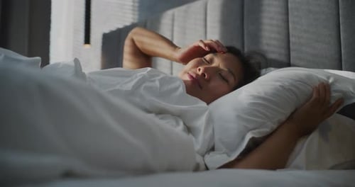 Young Woman Wakes Up Early in Morning In Bedroom