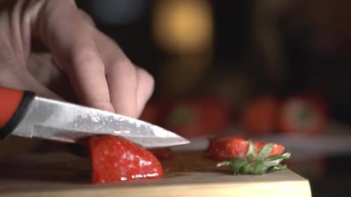Slicing A Red And Juicy Strawberries In the Kitchen. - close up shot