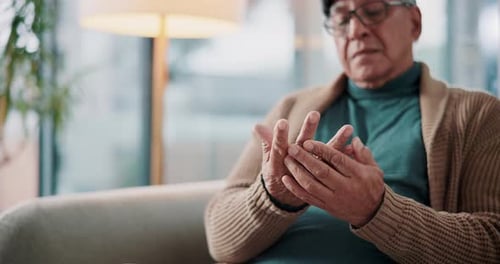 Elderly man, hands and arthritis with joint pain, ache or fibromyalgia from inflammation on sofa