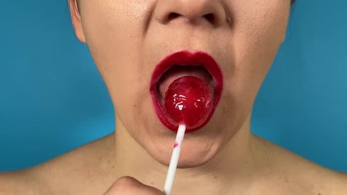 Gros plan : bouche féminine, lèvres colorées, mange des aliments sucrés, fond isolé