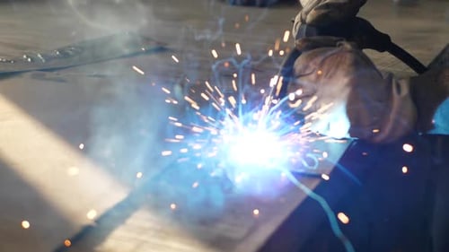 Welder on the table welds a set of metal parts. Welder working. Working with metal