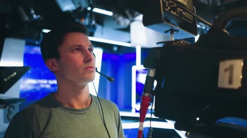 Cameraman Wearing Headset Operating Broadcast Camera in Bright Studio Environment