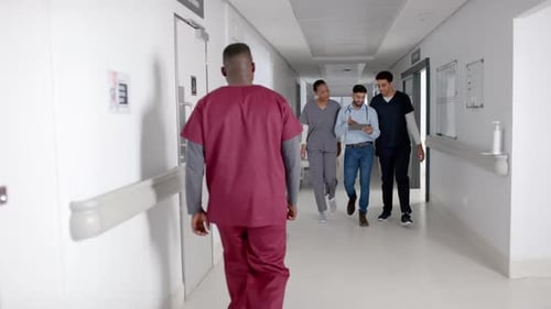 Diversos profesionales de la salud caminan por el pasillo de un hospital