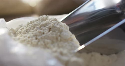 An experienced chef in a professional kitchen prepares the dough with flour to make the bio Italia