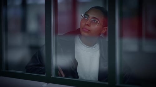 A Person is Observing the Urban Scene From a Window at Night Deep in Contemplation