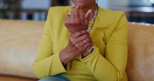 Stress, hand pain and senior woman on sofa with arthritis, disaster or muscle