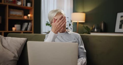 Senior woman, caregiver and laptop in home for help, support and care on sofa in living room