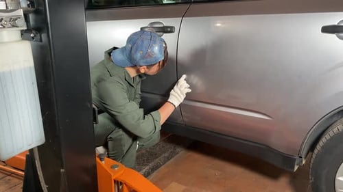 Professional Woman Mechanic Inspecting Car Body