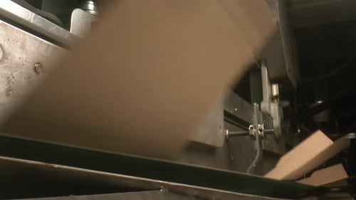 Werkzeugmaschine faltet und transportiert Kartons im Werk