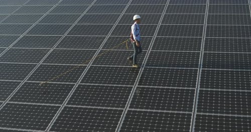 Aerial shot of assistance technical worker in uniform checking operation and efficiency of photovo