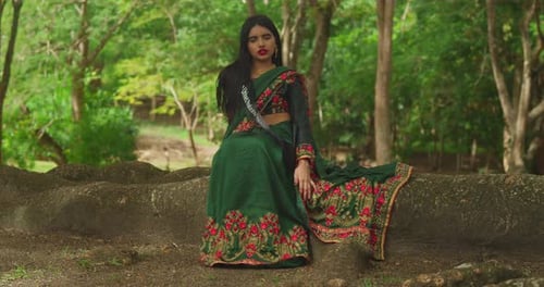 Dressed in traditional Indian wear, a young girl enjoys her day at a tropical park in the Caribbean.