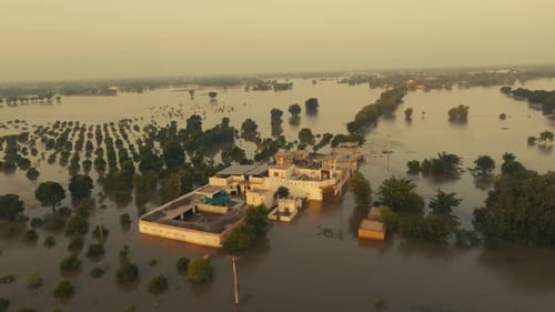 Forward aerial footage over flooded house complex in Jalalpur Pirwala, Pakistan