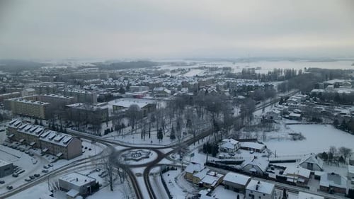 Aerial forward flight showing roundabout and small polish city during cold frosty winter day - Lubaw
