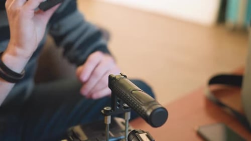 Closeup of Hands on Microphone Studio Gear in Focus with Blurred Background