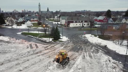 Aerial view over bulldozer operating clean-up after deadly winter snow storm, Buffalo, New York