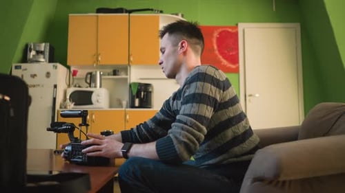 Person Seated Adjusting Video Camera Attaching Microphone