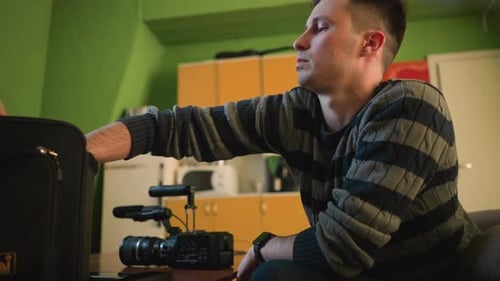 Person Reaching Into Camera Bag Adjusting Camera Equipment