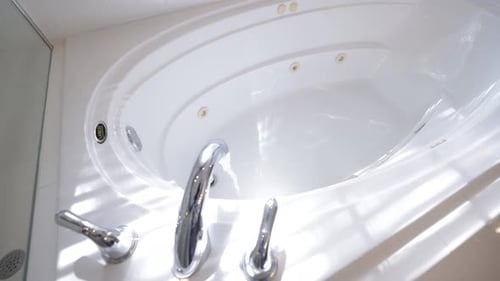 Wasser fließt in eine luxuriöse weiße Badewanne, Superzeitlupenvideo.