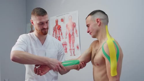 Kinesiology Therapist Applying Kinesio Tape to a Man Trauma Treatment