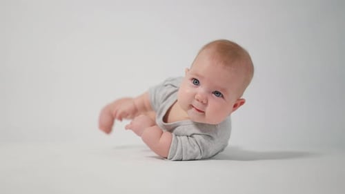 Portrait of a baby. A baby lying on his stomach in close-up against a white background,