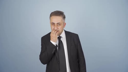 Stressed businessman biting nails.
