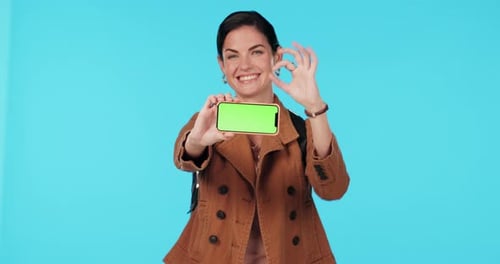 Green screen phone, okay and happy woman point at mobile app mockup, commercial agreement