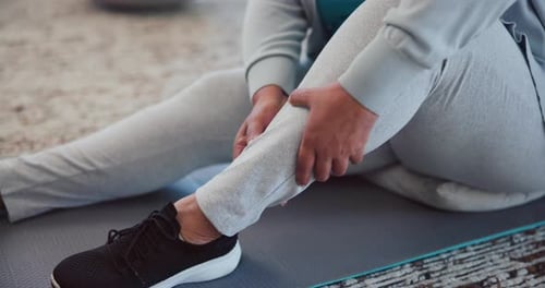 Lesión, piernas y persona con calambres, masajes y tensión muscular a causa de una distensión en el gimnasio, haciendo ejercicio o por una lesión