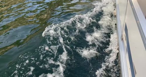 Ripples left by the water in the sea as a motor boat sails over it. 4K