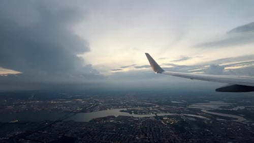 Wing of Flying Above Soft Fluffy Clouds Airplane As Seen By Passenger Through Porthole