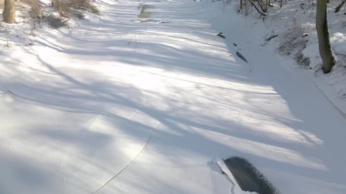 Aerial shot of the small river frozen during strong winter in northern Europe