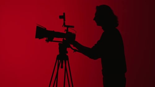 Silhouette of Cameraman Operating a Professional Camera