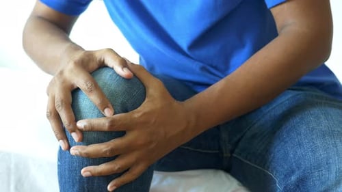 Homem com dor nas articulações do joelho