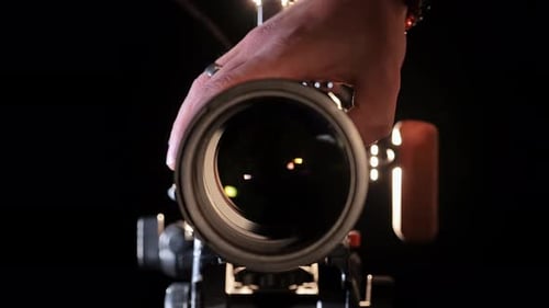 Capturing Light A Hand Adjusts Professional Camera Lens in Studio