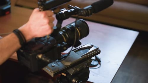 Closeup of Person Adjusting Camera on Tripod with Quick Release Plate