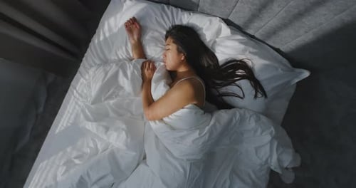 In Morning Young Girl Sleeps in Cozy Bed in Stylish Bedroom