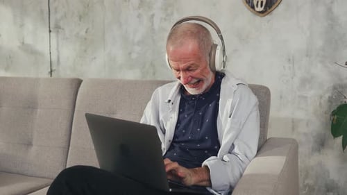 Cheerful Old Man Follower Writes Social Media Comment on Laptop