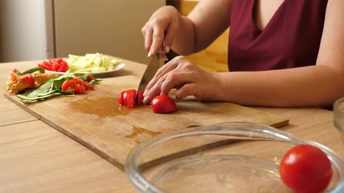 04Cut the tomato into pieces with a knife. Preparing vegetable dishes.