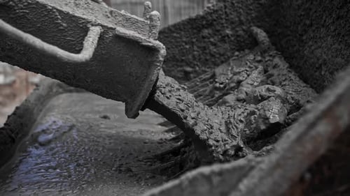 Concrete Pours From a Mixer at a Construction Site