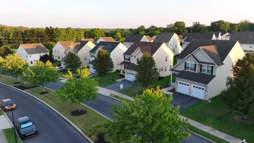 USA neighborhood during summer sunset. Aerial shot of houses and homes in American suburb.