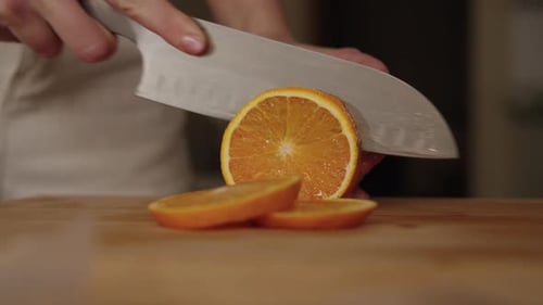 Side View of Unrecognizable Woman Slicing Fresh Orange on Wooden Cutting Board Preparing Ingredients