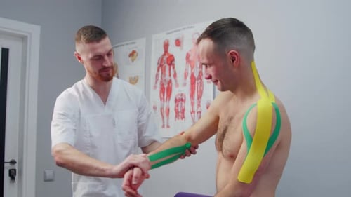 Kinesiology Physiotherapist Checks Kinesio Tape on a Man Treatment of Injuries