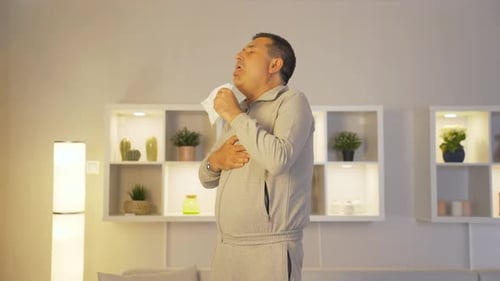 Hombre que se cubre la boca y la nariz mientras tose.