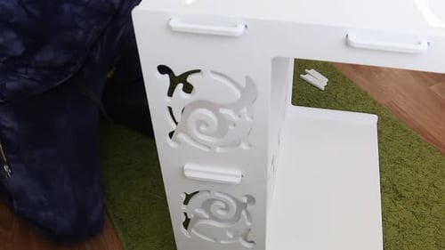 A Man Is Assembling A Plywood Computer Desk. Checks And Adjusts The Latches In The Grooves