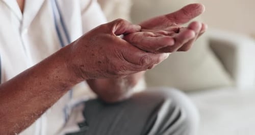 Manos, lesiones y artritis con masaje con la palma de la mano en el sofá con dolor en las articulaciones, túnel carpiano